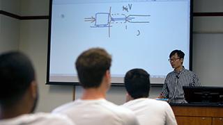 Image of a professor at a whiteboard.